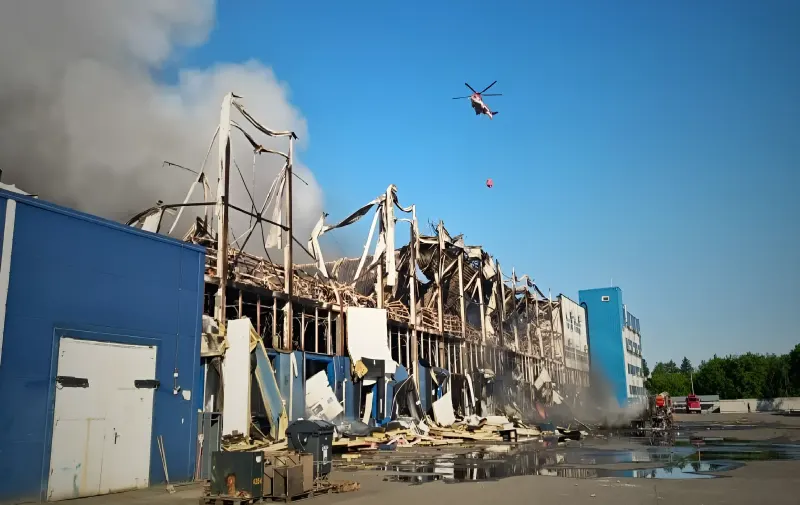 Пожарный вертолет сбрасывает воду на горящий склад после обстрела на Киевщине