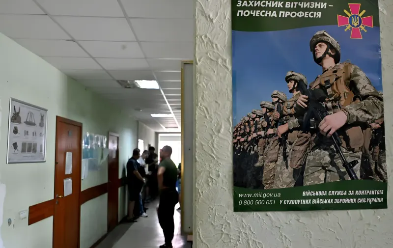 Постер про мобілізацію в Україні з написом «Захисник Вітчизни — почесна професія» у коридорі ТЦК