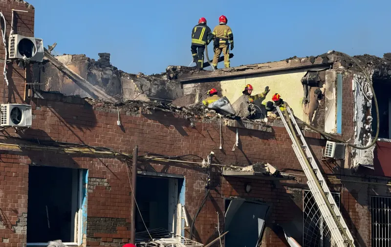 Пожарные тушат пожар в разрушенном здании после ракетного обстрела в Киеве