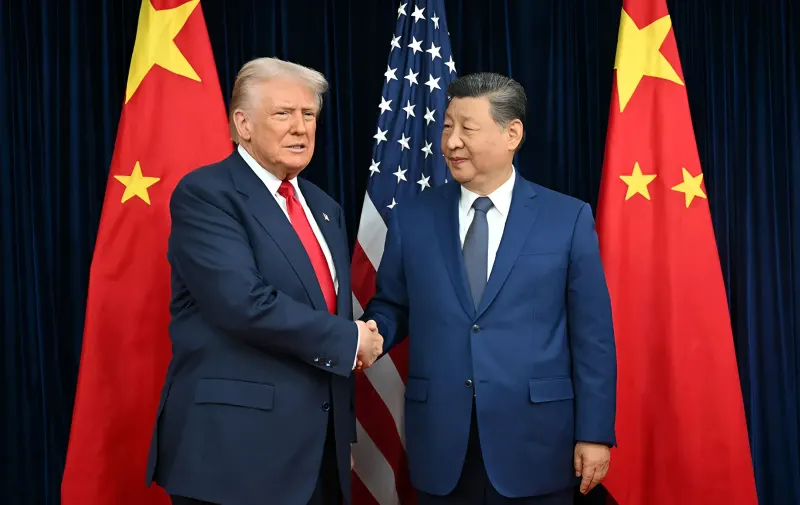 Си Цзиньпин и Дональд Трамп пожимают руки на фоне флагов Китая и США во время саммита в Пекине
