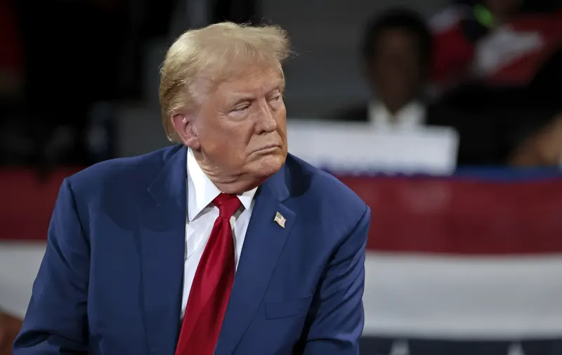 Дональд Трамп у синьому костюмі з червоною краваткою, що символізує його рішучу позицію щодо ядерної угоди з Іраном