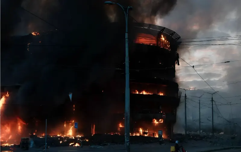 Масштабна пожежа в Києві під час масованого обстрілу Росією. Вогонь охопив будівлю, небо затягнуте чорним димом.