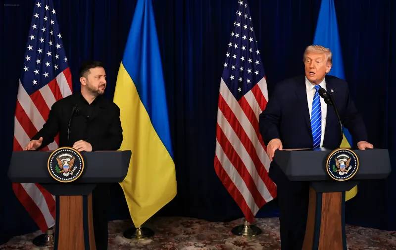 Владимир Зеленский и Дональд Трамп стоят у трибун на фоне флагов Украины и США