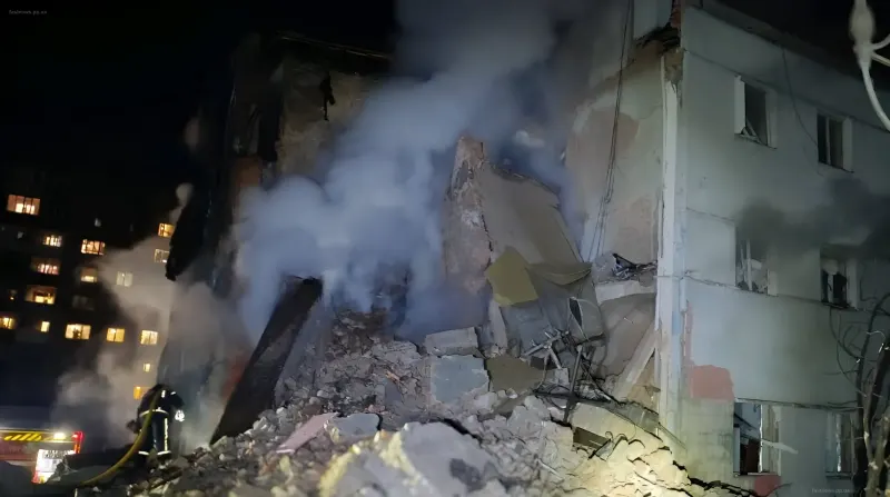 Разрушенное здание после удара дрона в Шостке, пожарные тушат огонь среди обломков