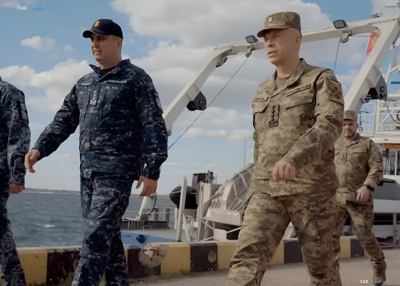 Украинские военные в камуфляжной форме на палубе корабля на фоне морской операции