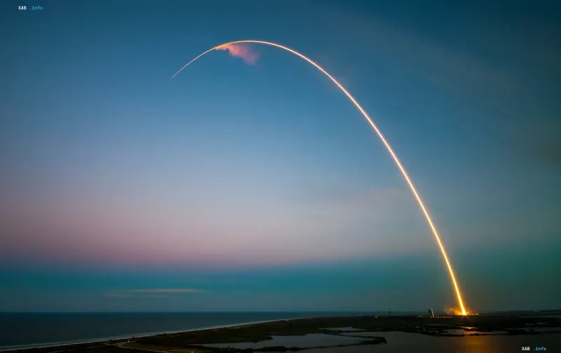 Запуск ракеты SpaceX с ярким огненным следом в небе на фоне заката, символизирующий начало испытаний капсулы Starfall и рождение космических фабрик