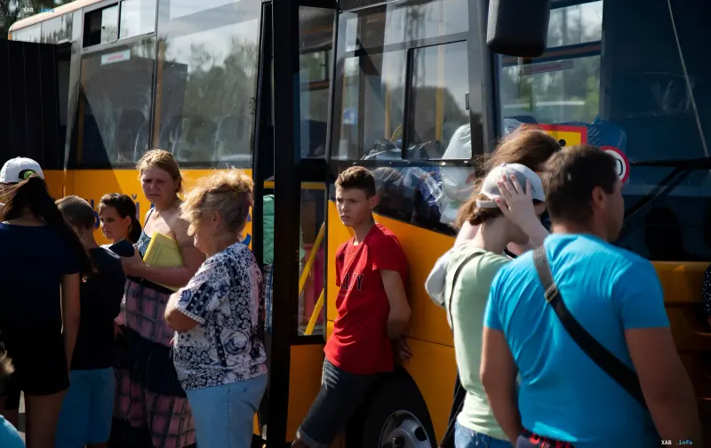 Семьи с детьми ожидают посадки в автобус для эвакуации в Донецкой области