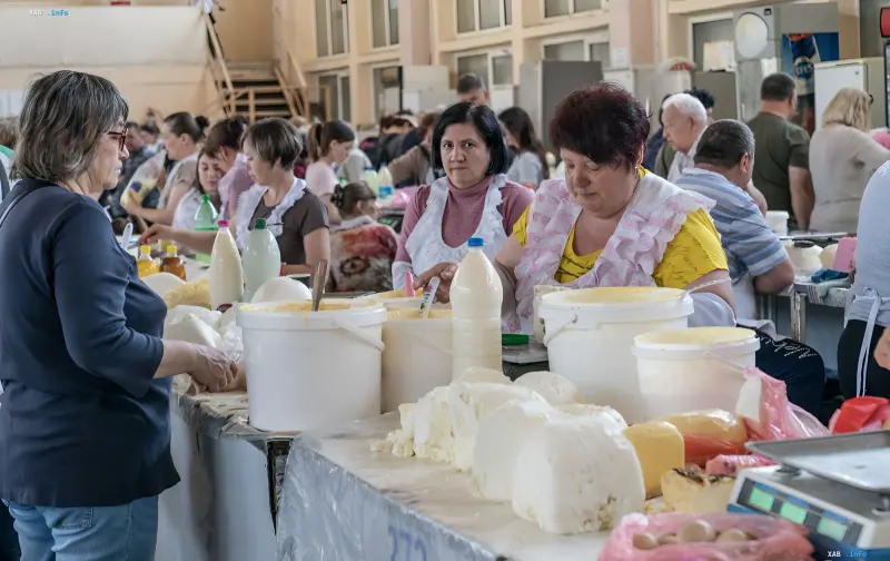 Жінки продають молочні продукти на ринку в прифронтовій зоні України, демонструючи перехід від офісної роботи до торгівлі через війну