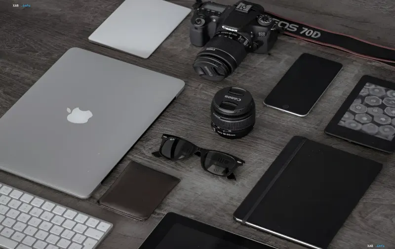 Workspace with Apple laptop, Canon camera and other gadgets amid news of sharp price hikes in tech