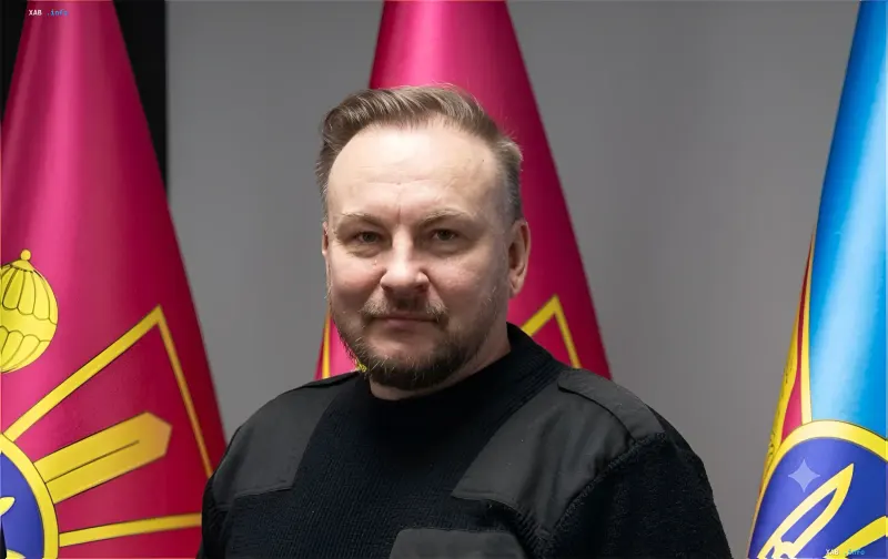 Belarusian military expert or representative of the Belarusian Armed Forces in front of state flags, illustrating the topic of disabling relay stations for Shahed drones