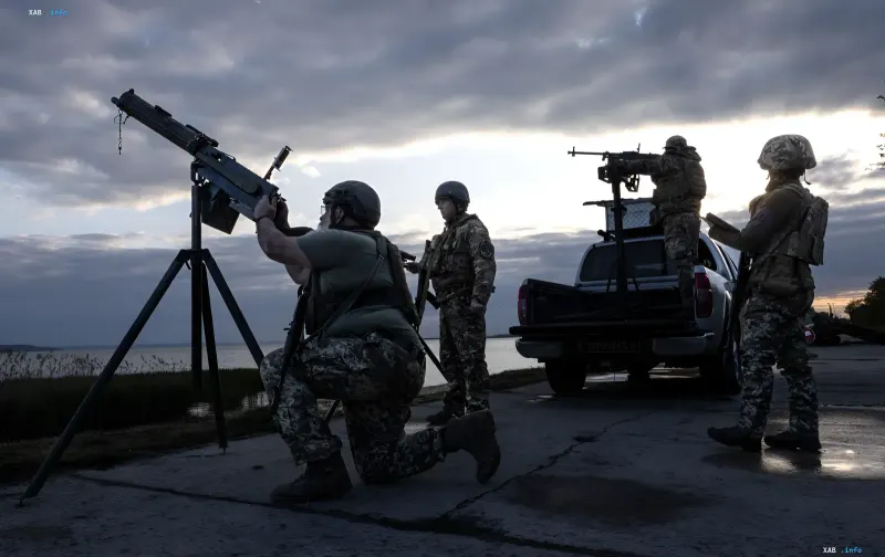 Украинские военнослужащие с пулеметами на позициях у воды в сумерках — отражение массированной атаки дронов РФ 29 июня