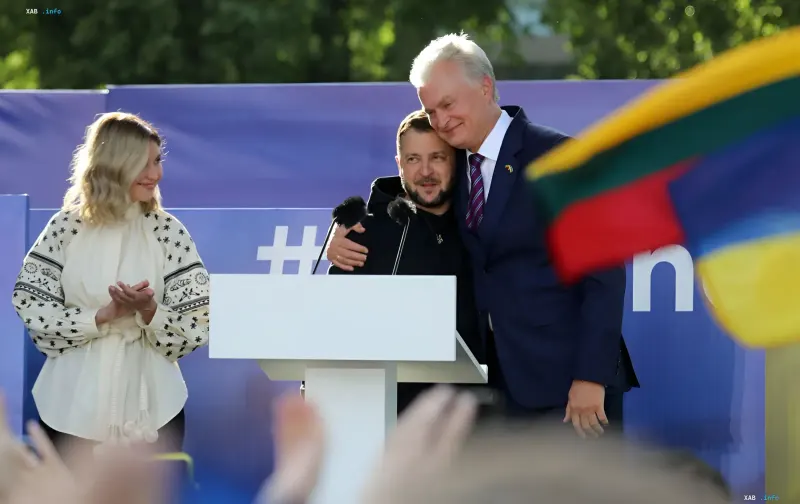 Президент Украины Владимир Зеленский обнимается с президентом Литвы Гитанасом Науседой на фоне флага Литвы во время срочного саммита в Юрате