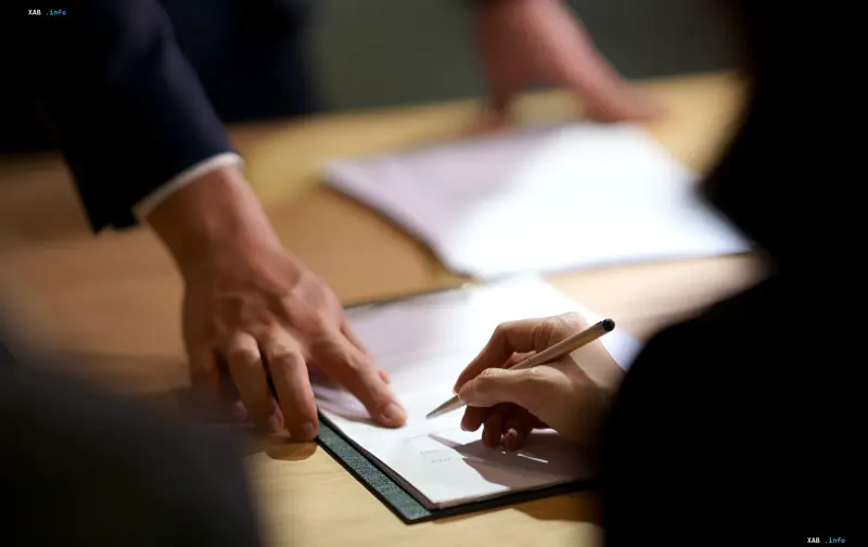 Unterschrift eines Arbeitsvertrags: Symbol für den Übergang zum neuen Arbeitsgesetzbuch in der Ukraine