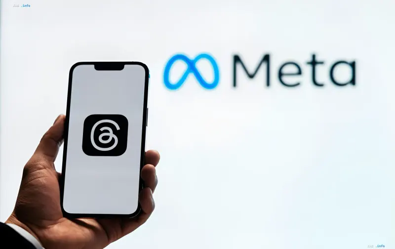 Smartphone with Threads logo on the screen and blurred Meta logo in the background, symbolizing the update of Live Chats with translation and moderation