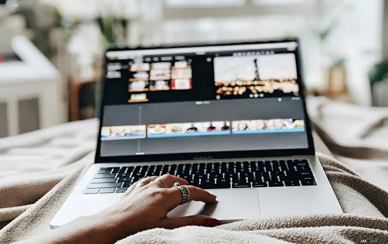Female hand with rings working on MacBook Pro, video editing interface on screen; illustration for news about Google’s autonomous AI agent Gemini Spark for macOS