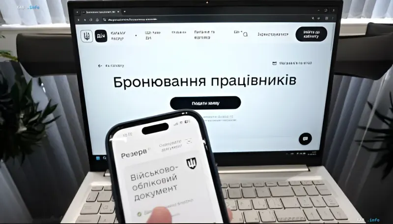Ноутбук с интерфейсом бронирования работников и смартфон с военным учетным документом — символ новых правил для критических предприятий Украины