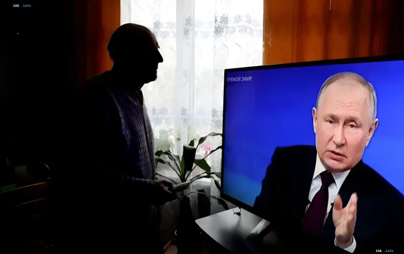 Ein älterer Mensch sieht sich im Fernsehen an, wo Wladimir Putin eine Provokation in der Region Brjansk ankündigt und versucht, Belarus in den Krieg zu ziehen.