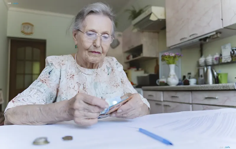 Ältere Frau zählt Geld und überprüft Dokumente, was das Thema der bevorzugten Rente und die Neuberechnung der Zahlungen nach 60 Jahren veranschaulicht