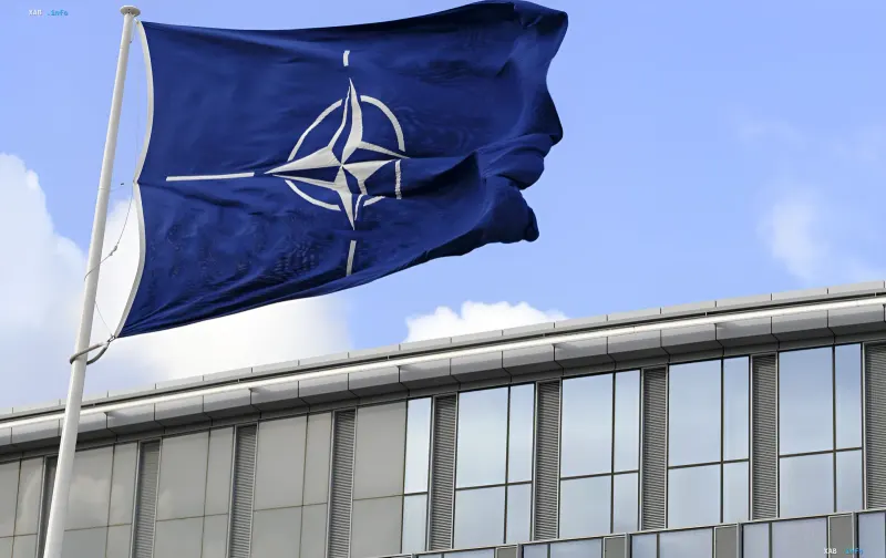 NATO flag waving above the headquarters building, symbolizing Ukraine's request for a new status in the alliance