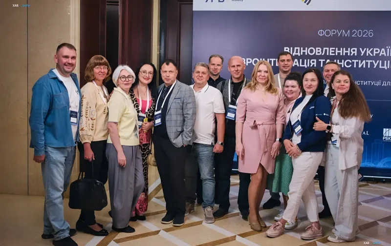 Учасники форуму «Відновлення України 2026» у Києві на фоні банера з темою податкової реформи та євроінтеграції