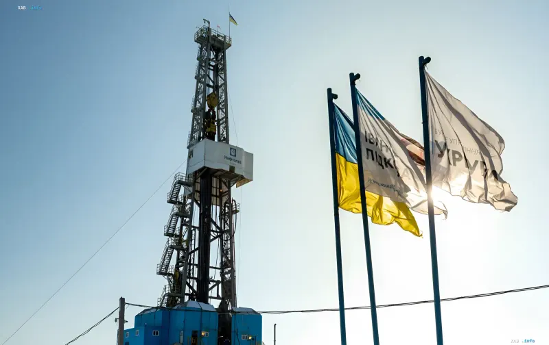 Бурова установка «Нафтогазу» на фоні українських прапорів — символ енергетичного суверенітету України в контексті судового спору з «Газпромом»
