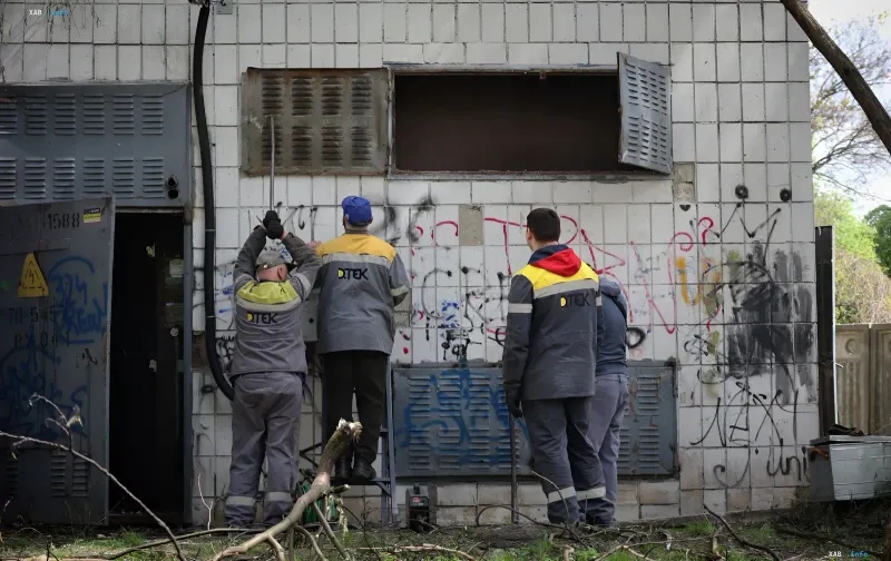 Arbeiter in DTEK-Uniformen stellen ein beschädigtes Gebäude nach Beschuss wieder her und demonstrieren die Arbeit nationaler Schnellreaktionsbrigaden