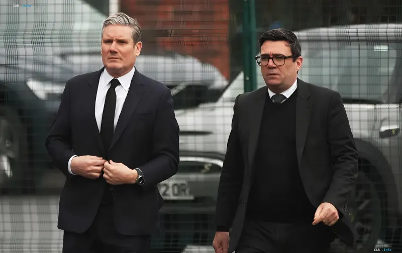 Andy Burnham und Keir Starmer in Anzügen vor einem Zaun, diskutieren die Pläne des neuen Premierministers und die Unterstützung für die Ukraine