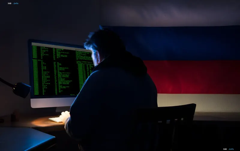 Hacker at a computer with a Russian flag in the background, symbolizing the hacking of surveillance cameras to track NATO military supplies to Ukraine