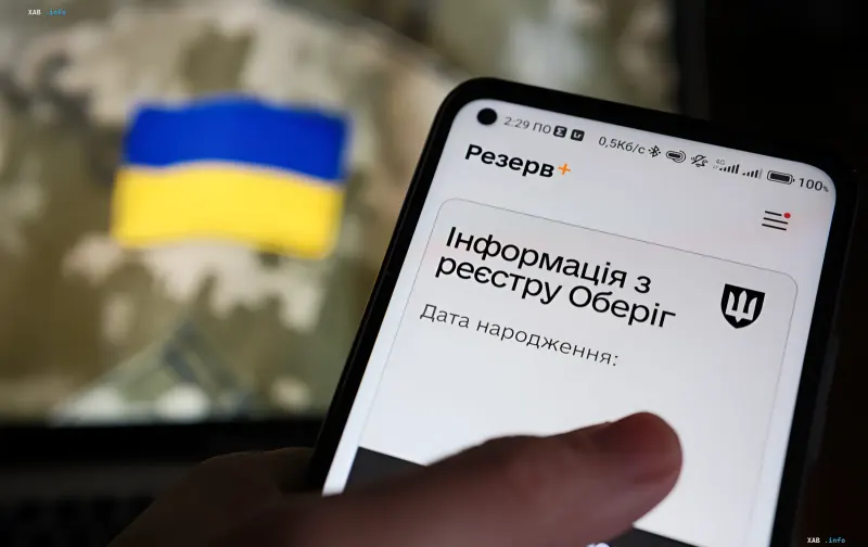 Смартфон з додатком Резерв+ та українським прапором на фоні — автоматичне продовження відстрок від мобілізації в Україні