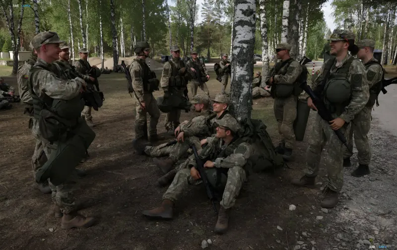 Литовские военные в камуфляже отдыхают в лесу, обсуждая патриотический бум и рекордное число добровольцев