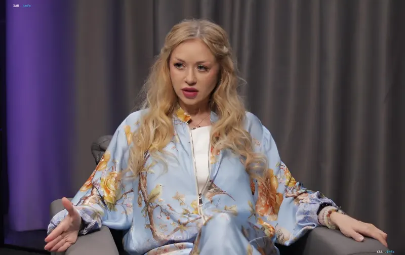 Natalia Valevskaya in a floral blue suit during an interview about motherhood and loss