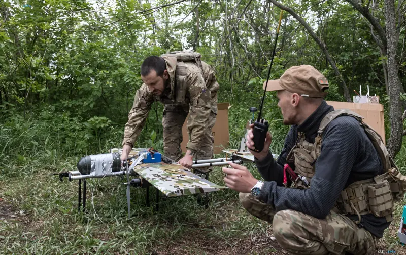 Ukrainian military engineers preparing combat drone Droid TW 12.7 for launch in the forest
