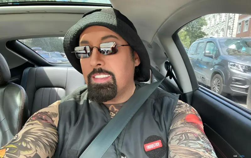 Dmitry Kolyadenko in a car: artist in a hat and glasses with tattoos on his arms, discussing love and dream about a grandson