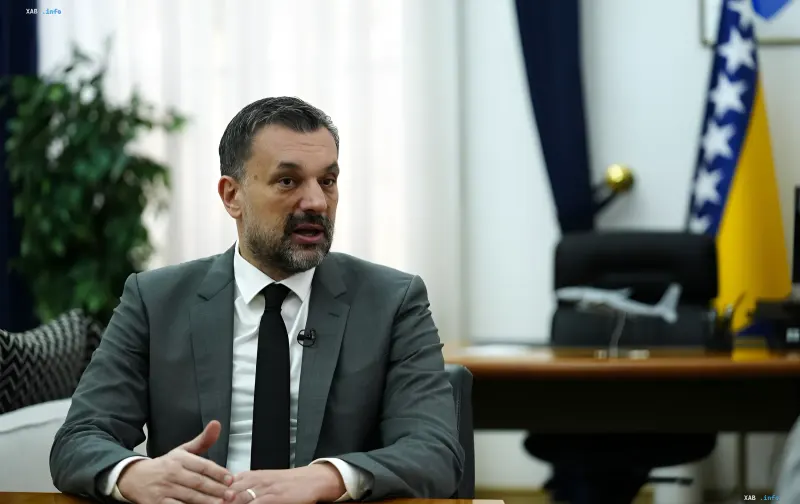 Vertreter von Bosnien und Herzegowina in einem Büro mit der Landesflagge, diskutiert Kritik an der EU wegen Doppelmoral bezüglich der Ukraine
