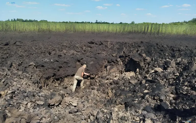 Слід від падіння ракети KN-23 поблизу Радуського: кратер і обвуглена земля, де людина оглядає наслідки удару