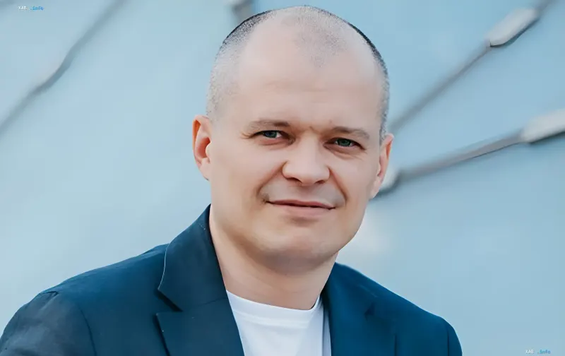 Businessman in a blue suit against modern architecture — symbol of Ukrainian entrepreneurship protected by long-term energy auctions