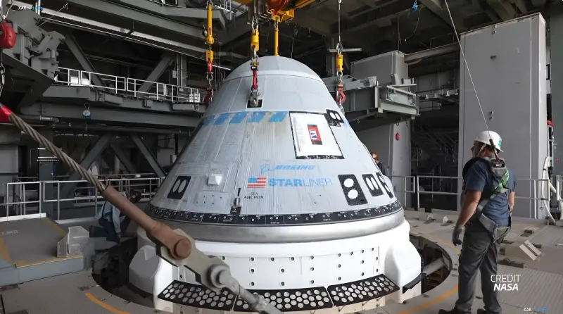 Raumschiff Boeing Starliner wird im Montagezentrum der NASA mit einem Kran gehoben im Rahmen der Vorbereitung auf eine neue ISS-Mission