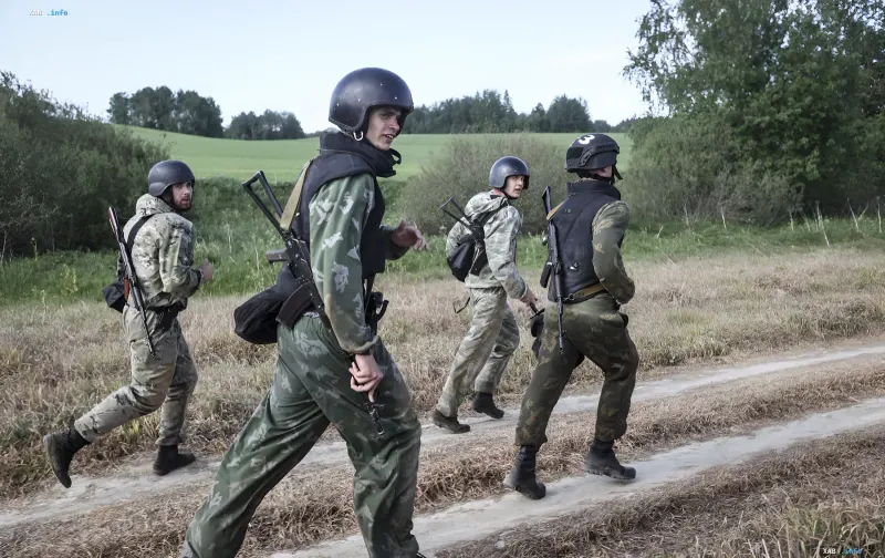 Белорусские военнослужащие в камуфляже и шлемах с оружием на фоне полей, новое десантно-штурмовое подразделение на границе с Украиной