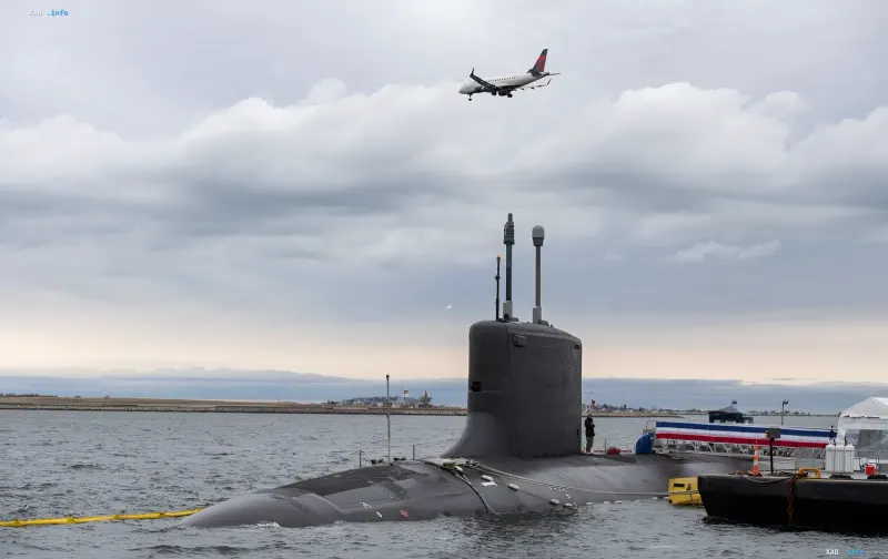 Американская атомная подводная лодка на поверхности воды с самолетом на фоне, иллюстрирующая масштабные инвестиции Пентагона в подводный флот