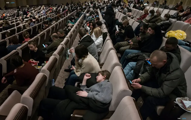 Украинские беженцы в зале временного размещения, мужчины призывного возраста на фоне новостей о новых правилах ЕС