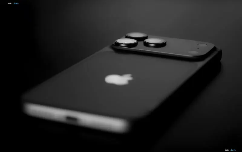 Черный iPhone с тремя камерами и логотипом Apple на темном фоне, иллюстрирующий скрытые функции доступности iOS 26