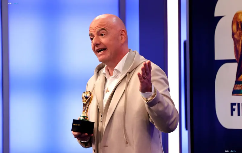 FIFA-Präsident Gianni Infantino mit einem Trophäe vor dem Hintergrund des Logos der Organisation