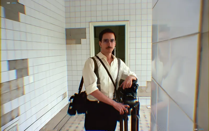 Alexander Martynenko, Puppentheater-Schauspieler und Kurator von DAKH School, in einem weißen Interieur mit Koffer