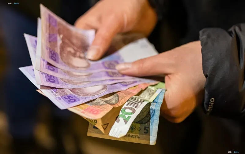 Hands counting Ukrainian hryvnia banknotes — illustration for news on Ukraine’s inflation accelerating to 7.7% in July 2026