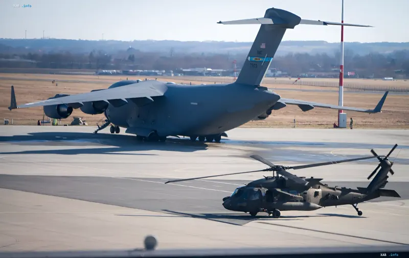 Бойовий вертоліт Apache на аеродромі поруч із транспортним літаком C-17 — ілюстрація до новини про катастрофу в Техасі