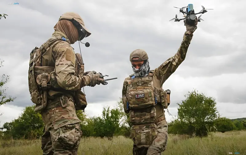Ukrainian soldiers training with NATO allies: one holds a drone, another operates a controller, showcasing counter-drone tactics