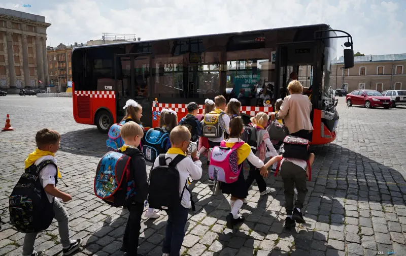 Eine Gruppe von Schulkindern mit Rucksäcken steigt in einen Stadtbus, was die Bedeutung der Verkehrsanbindung für jede Siedlung im Rahmen des Logistikaudits des Landes veranschaulicht