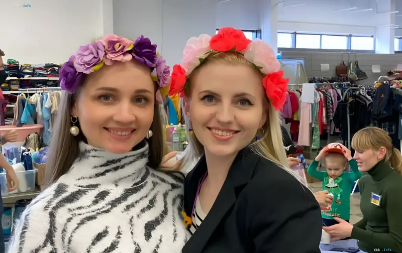 Українські жінки у квіткових вінках посміхаються на фоні гуманітарної допомоги, символізуючи реальну підтримку ЄС, яку спотворює російська пропаганда в контексті «Резерв+»