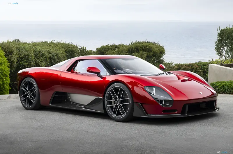 Червоний McLaren McLaren 6GT на фоні узбережжя, демонструє класичний дизайн та механічну коробку передач