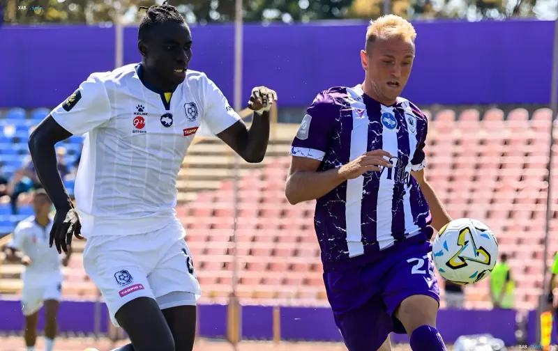 LNZ-Spieler im weiß-blauen Trikot kämpft um den Ball mit Chornomorets-Spieler im lila Trikot während eines Spiels in Tschernihiw